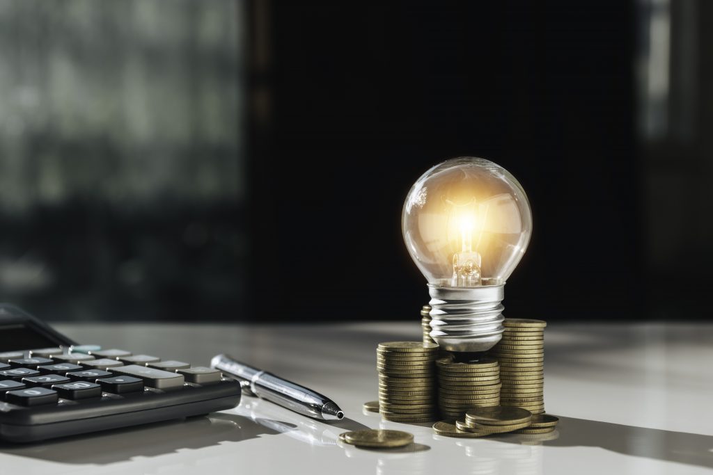Coins And Light Bulb On Table For Saving Money,energy Concept.