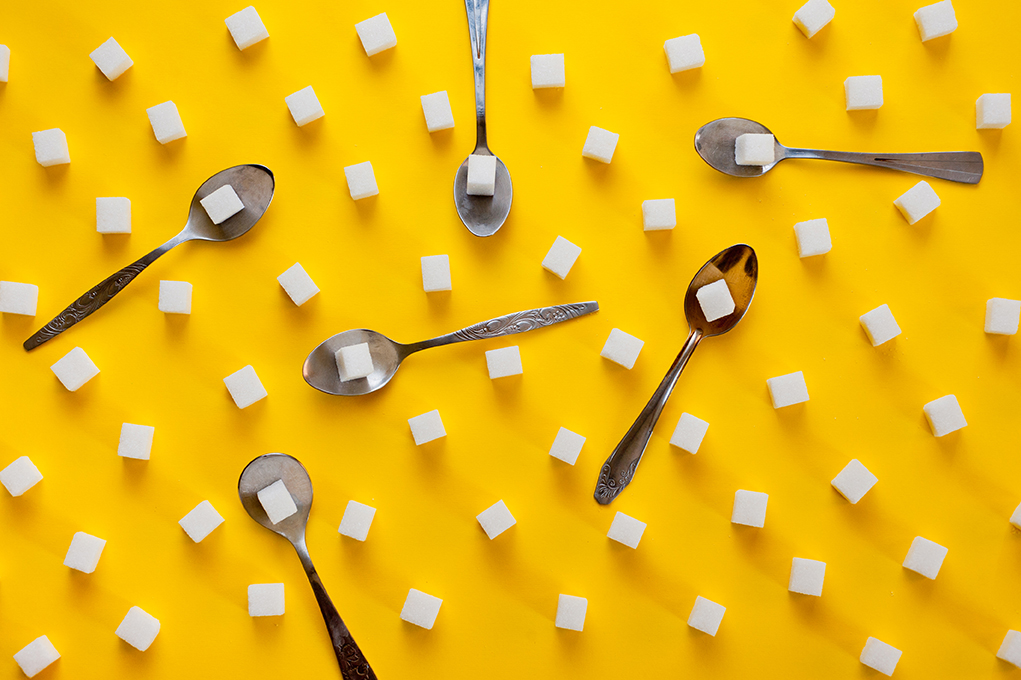 Refined Sugar Cubes And Teaspoons Shot On A Yellow Background. B